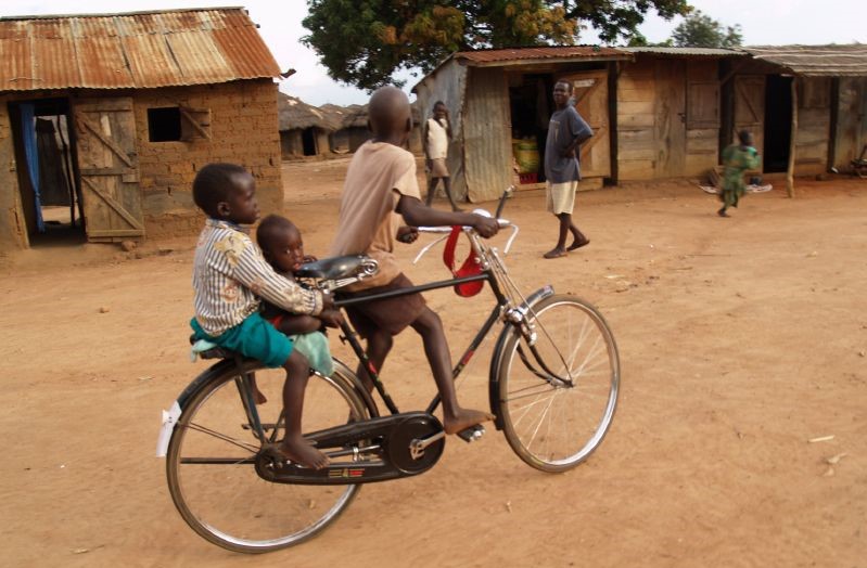 Children riding a bike in Uganda. Photo by Robin Yamaguchi.