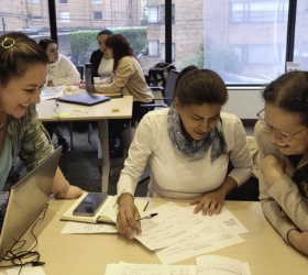 3 workshop participants around a table discuss indicators to measure and evaluate Colombia’s progress in child protection and case management.